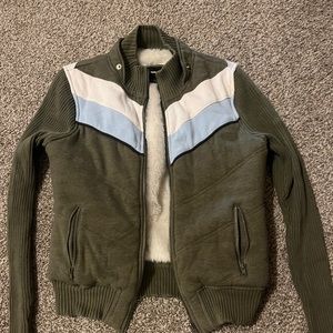 Medium sized green jacket with white and blue zig zags and a furry inside.